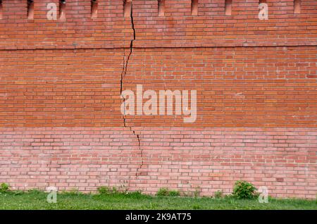 Long vertical crack in a red brick wall Stock Photo