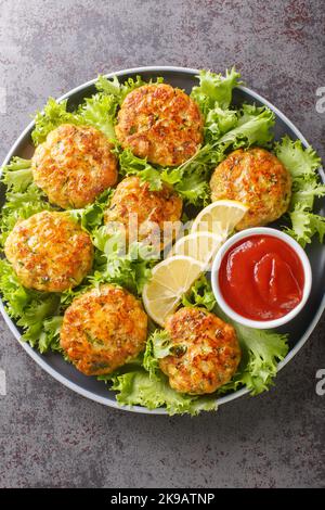 Australian chicken meatballs with cheese, carrots, zucchini and herbs close-up in a plate on the table. Vertical top view from above Stock Photo