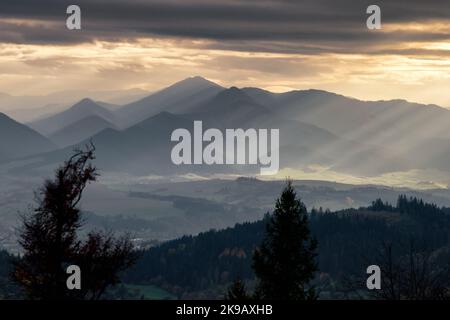 The sun magically shines through a gap through the cloud producing amazing sun ray in the sky. Stock Photo