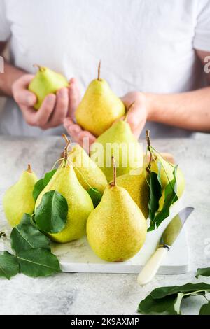 https://l450v.alamy.com/450v/2k9axmp/pears-fresh-sweet-organic-pears-with-leaves-on-stand-or-plate-and-in-the-background-male-hands-hold-pears-frame-of-autumn-harvest-fruits-top-view-2k9axmp.jpg