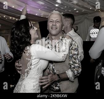 Bride dancing at wedding with guest. Stock Photo