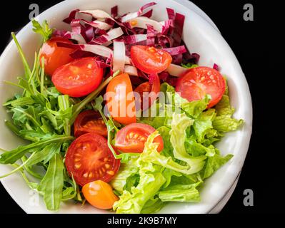 Mixed salad with lettuce,tomato and fresh rucola leaves. vegetarian dish. Stock Photo