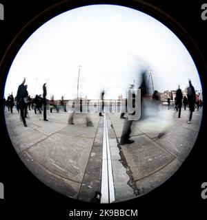 London Commuters. Creative high contrast abstract of urban professionals and office workers on their way to work. 180 degree wide angle fish eye view. Stock Photo