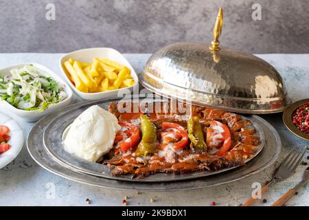 Turkish iskender kebab on gray background. Traditional flavors. Doner kebab made from beef and lamb. close up Stock Photo