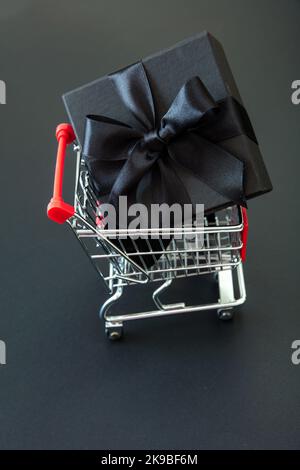 Gift box in a Shopping Cart. Black Friday Sale, Christmas presents. E commerce, online shop sales concept Stock Photo