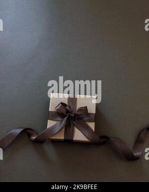 Gift box with black ribbon isolated on black, top view, copy space. Black Friday Sale template Stock Photo