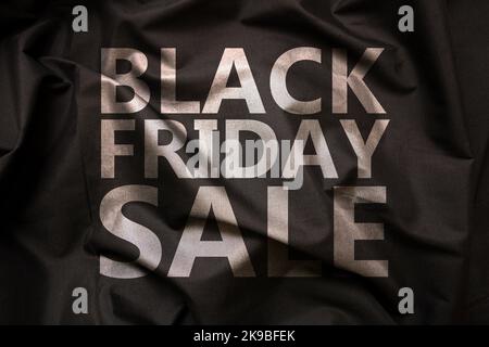 Black Friday Sale text on satin textile background. Store promotion sign. Fashion and clothes sales concept Stock Photo