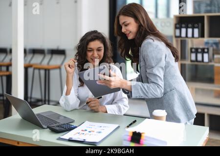 Diverse businesspeople cooperate work together discussing company financial statistics, multiracial colleagues collaborate brainstorm with finance on Stock Photo