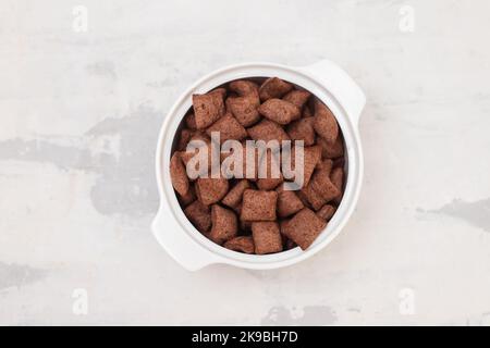 chocolate cereals in small white bowl on ceramic Stock Photo