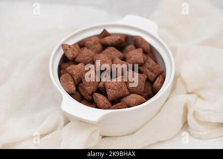 chocolate cereals in small white bowl on ceramic Stock Photo