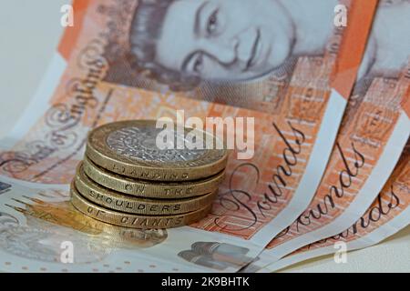 Bank of England, Sterling bank notes, with two pound coins showing inscription, 'Standing on the shoulders of giants". Coins & note hard currency cash Stock Photo