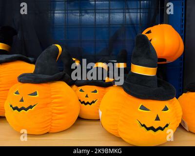 Halloween product orange pumpkin wearing witch hat on sales on the shelf, users can buy it home for decoration. Stock Photo