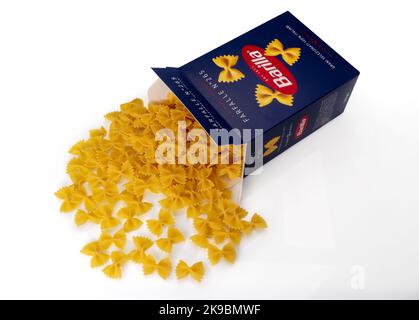 Turin, Italy - october 15, 2022: Macaroni farfalle pasta Barilla, bow tie shaped pasta come out of blue package isolated on white, Barilla is world fa Stock Photo