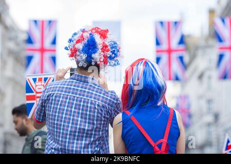 Revellers in Union Jack-themed costumes gather in Piccadilly Circus, central London, on the first day of the Platinum Jubilee weekend. Stock Photo