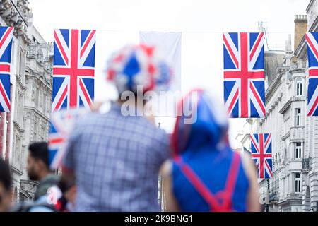 Revellers in Union Jack-themed costumes gather in Piccadilly Circus, central London, on the first day of the Platinum Jubilee weekend. Stock Photo