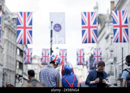 Revellers in Union Jack-themed costumes gather in Piccadilly Circus, central London, on the first day of the Platinum Jubilee weekend. Stock Photo