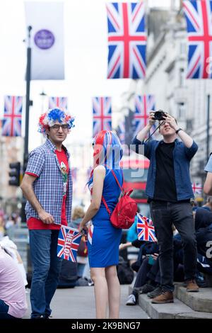 Revellers in Union Jack-themed costumes gather in Piccadilly Circus, central London, on the first day of the Platinum Jubilee weekend. Stock Photo