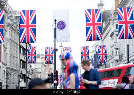 Revellers in Union Jack-themed costumes gather in Piccadilly Circus, central London, on the first day of the Platinum Jubilee weekend. Stock Photo