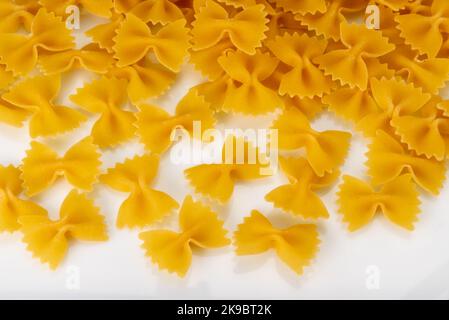 Italian pasta called farfalle, raw macaroni in the shape of bow tie isolated on white, top view Stock Photo