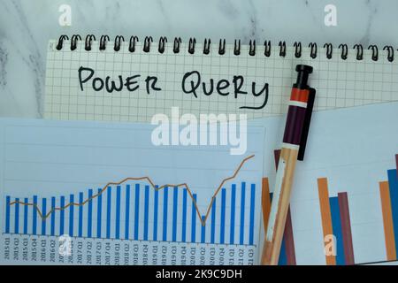 Concept of Power Query write on a book with statistics isolated on Wooden Table. Stock Photo