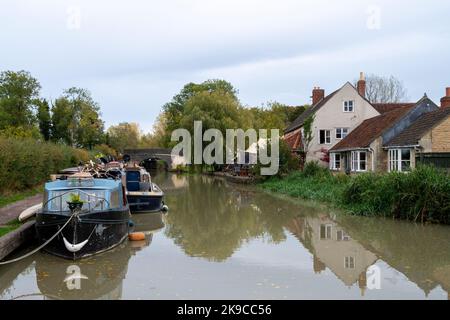 Barges and narrowboats on the Kennet and Avon Canal moored by The Barge Inn, near Seen Lock, Wiltshire UK Stock Photo