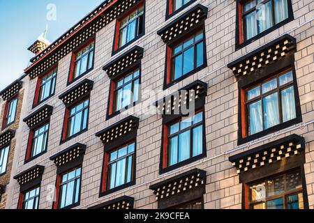Exterior of glass windows on oriental design hotel building pattern in downtown Stock Photo