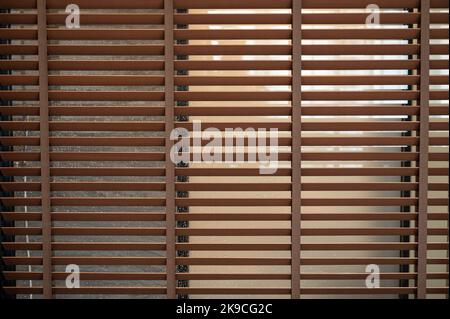 Pattern of brown wooden blinds on glass window in bathroom Stock Photo