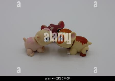 Tiny, cute plastic kissing guinea piganimal figure on a white background. Collectible isolated littlest pet shop figure with big head and big eyes. Stock Photo