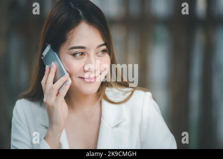 Happy Young Asian executive business woman in  marketing working talking on mobile phone and asking about something ,Corporate Communication concept. Stock Photo