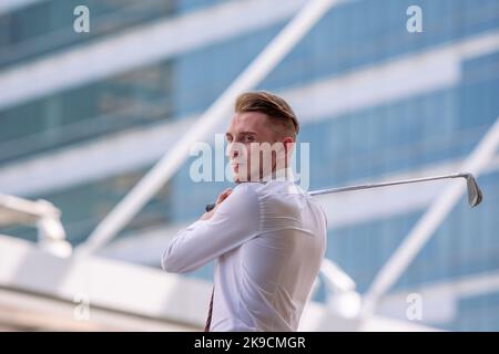 Young cuacasion confident CEO Businessman wearing white shirt with golf club in the city. Stock Photo
