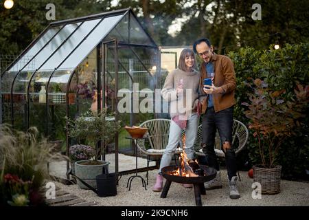 Young couple by the fire at backyard Stock Photo