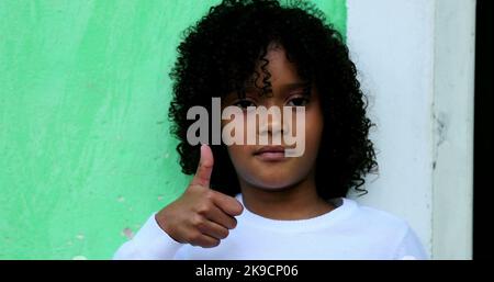 African child gives thumb up, black kid positive signal Stock Photo