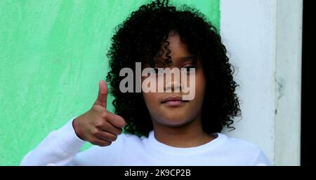 African child gives thumb up, black kid positive signal Stock Photo