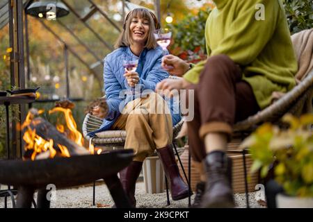 Young couple spending dinner time by the fire at backyard Stock Photo