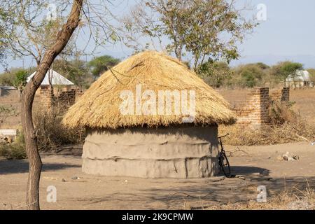 Tarangire, Tanzania - October 12th, 2022:A Masai mud hut with a straw roof in a tanzanian savannah. Stock Photo