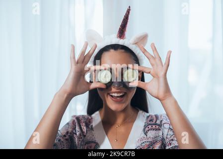 Funny smiling Spa Woman with fresh Facial Mask hold cucumbers. Stock Photo