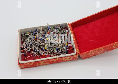 Sewing accessories on a white background. Pins in a big red box Stock Photo
