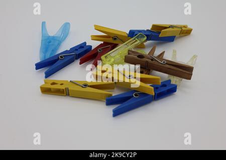 Colorful clothespins or clothes pegs laying on a white background Stock Photo