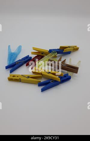 Colorful clothespins or clothes pegs laying on a white background Stock Photo