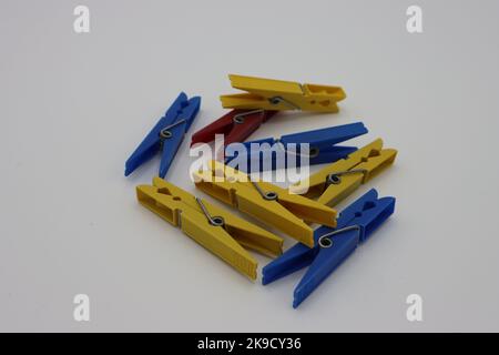Colorful clothespins or clothes pegs laying on a white background Stock Photo