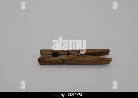 Wooden clothespins or clothes pegs laying on a white background Stock Photo