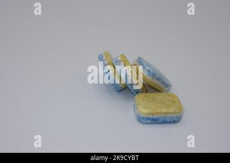 Dishwasher tabs or tablets in a water soluble transparent film packaging on a white background Stock Photo