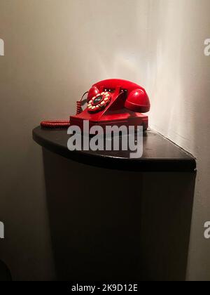 A red phone on a table. Emergency telephone. Stock Photo