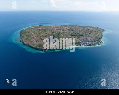 A fringing reef grows along the edge of a remote, tropical island near Alor, Indonesia. This region is known for its high marine biodiversity. Stock Photo