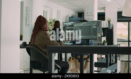 African american programer typing source code on computer to create new user interface. Software engineer writing data in html language to develop security server on terminal window. Stock Photo