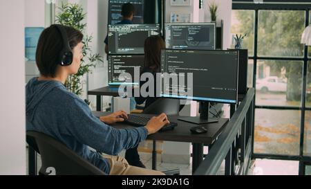 Junior developer programming code on terminal window, typing server information on computer. Programer coding database source with html script, developing algorithm and firewall security. Stock Photo