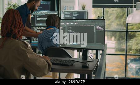 App software developer typing machine learning app code on computer, sitting at desk in big data company office. Cloud programer working on new program interface in cyber security agency. Stock Photo