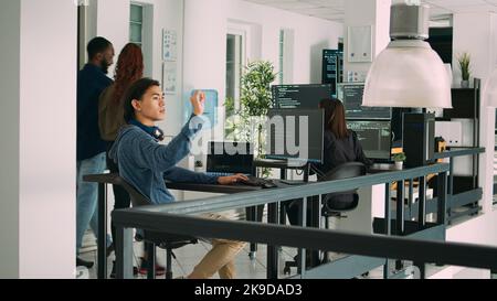 Digital developer analyzing ar hologram to work on html script, using holographic database interface with augmented reality. Cloud computing program with terminal window in office. Stock Photo
