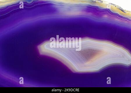 Purple and Blue agate slice crystal , banded chalcedony stone isolated on a white background surface with lots of detail. Copy space Stock Photo