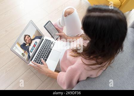Woman is having a video call on laptop. Young woman using video chat at home Stock Photo